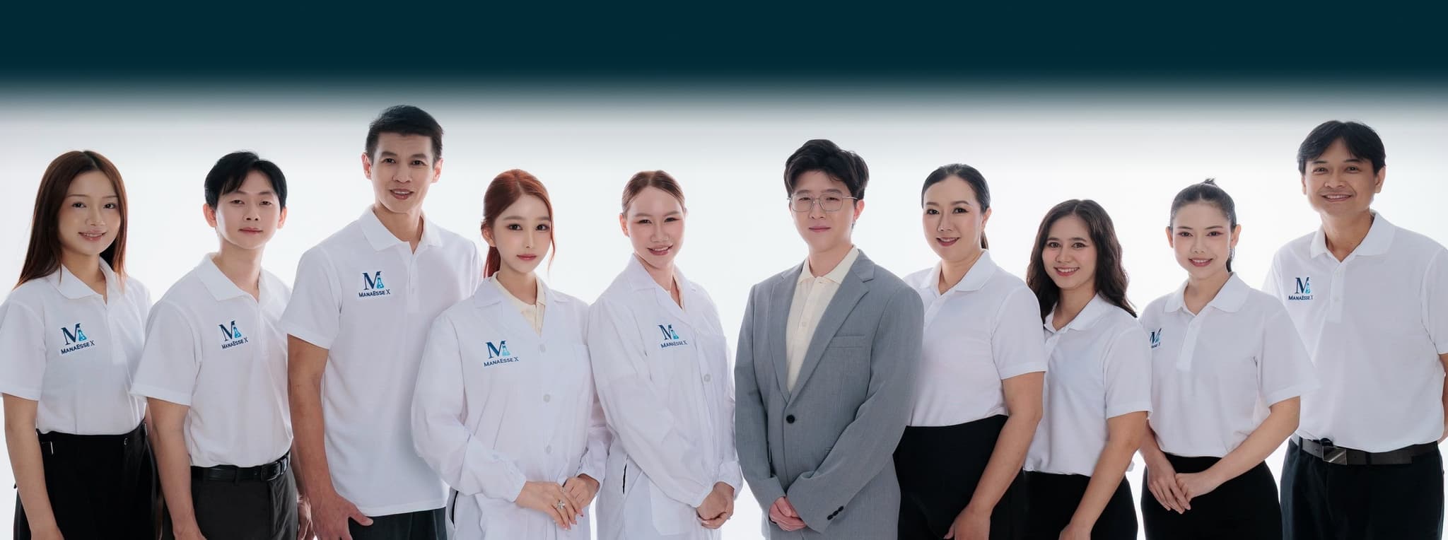 The ManaEsse X team in company polo shirts and lab coats, standing together in a studio.